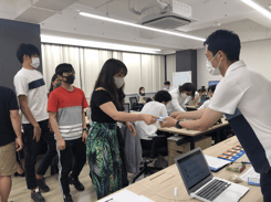 銀行役からお金を受け取るメンバー